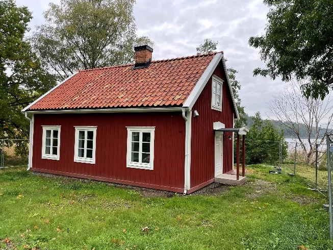 Kaptensstugan, rödmålad timmerstuga med tegeltak vid Hustegaholm