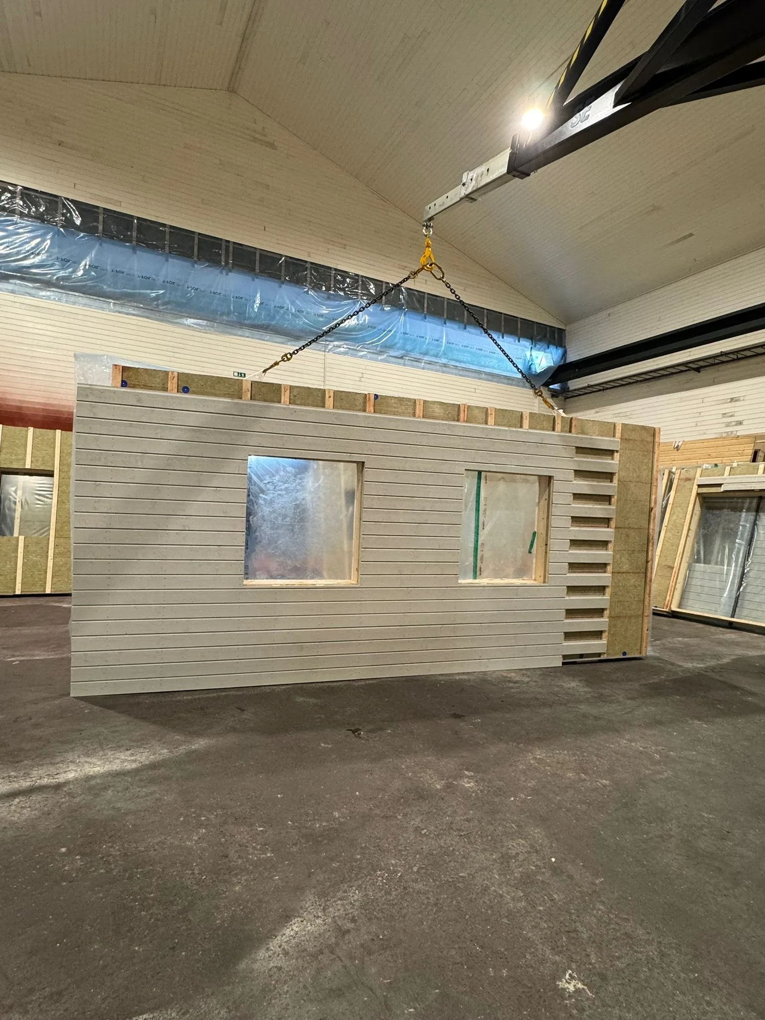 Prefabricerat väggelement lyfts med travers i fabrik